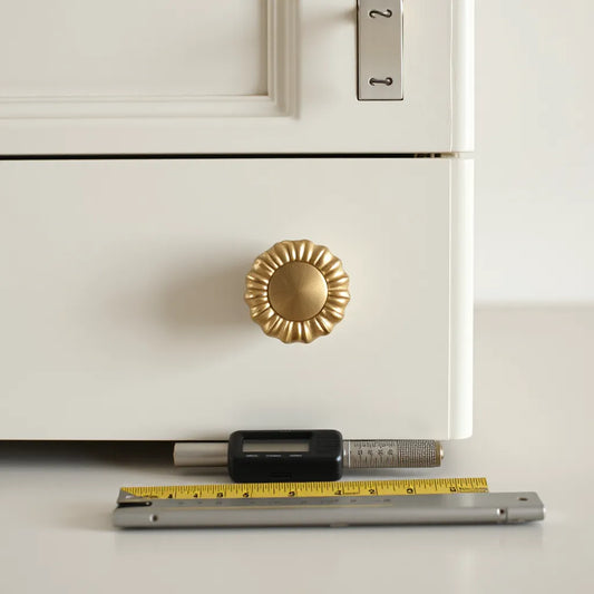 Hestia-style cabinet knob with measuring tools beside a kitchen cabinet door